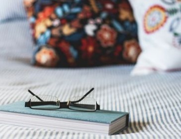 journal on bed with glasses